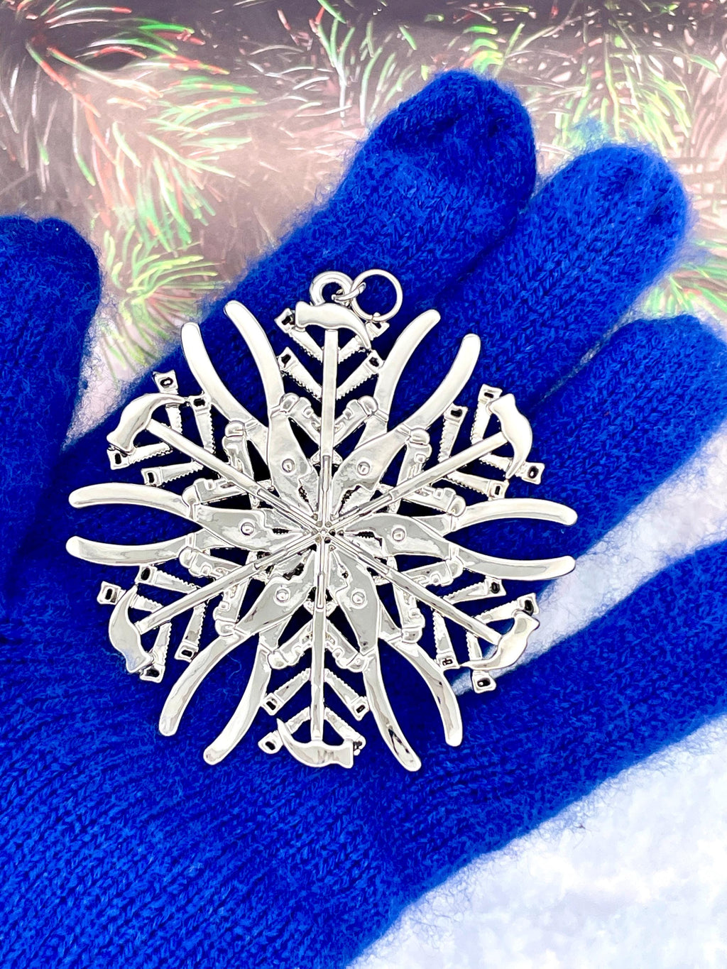 May include: A silver snowflake ornament with a detailed design. The snowflake is made up of many small, intricate pieces that are connected together. The snowflake is a popular Christmas decoration.